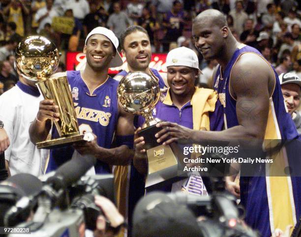 Los Angeles Lakers' Kobe Bryant, Rick Fox, Lindsey Hunter and Shaquille O'Neal hold their trophies before the media after capturing the 2002 NBA...