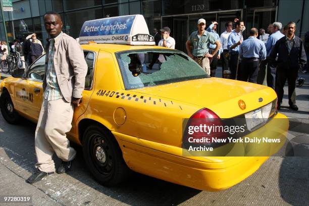 Cabbie Daniel Frimpong stands by his taxi cab that was damaged after a construction bucket slammed into the sidewalk after falling 52 stories from...