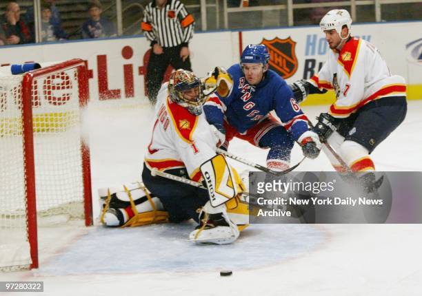 Florida Panthers' goalie Roberto Luongo deflects a shot taken by New York Rangers' Jaromir Jagr who is trailed by Panthers' Pavel Trnka during a game...