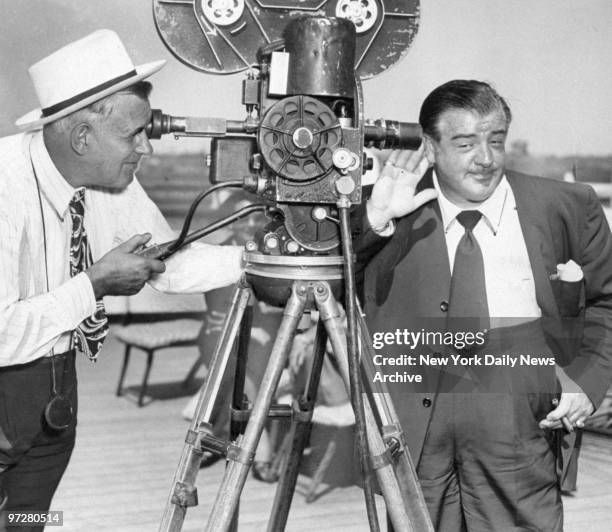 Lou Costello holds ear to camera aboard the Queen Elizabeth.