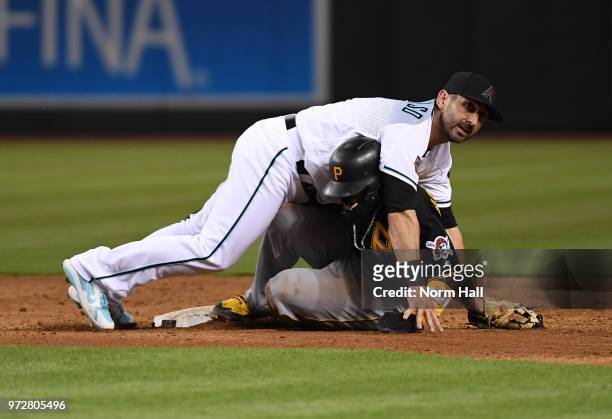 Daniel Descalso of the Arizona Diamondbacks falls onto Josh Harrison of the Pittsburgh Pirates after attempting to turn a double plat at second base...