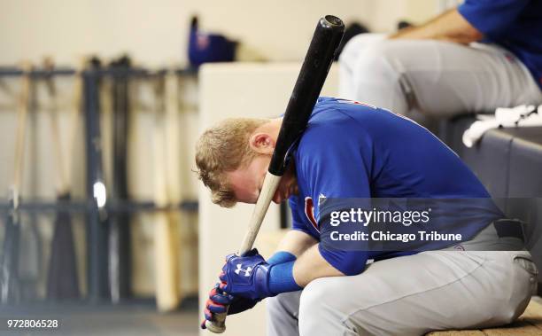 Chicago Cubs outfielder Ian Happ rests his head on a bat in the dugout in the fifth inning against the Milwaukee Brewers at Miller Park in Milwaukee...