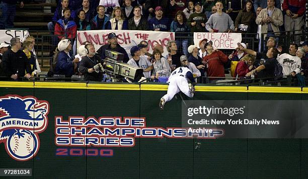 Seattle Mariners' Mike Cameron nearly flips over the centerfield fence while trying to snag a home run hit by Tino Martinez in the second inning of...