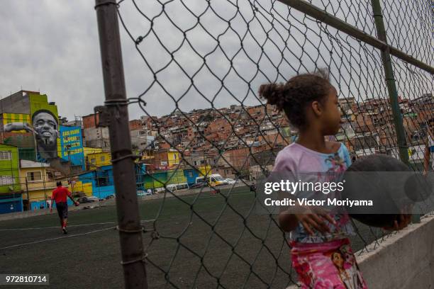 Children play soccer in front of the graffiti mural of the striker of the Brazilian soccer team Gabriel Jesus on June 12, 2018 in Sao Paulo, Brazil....