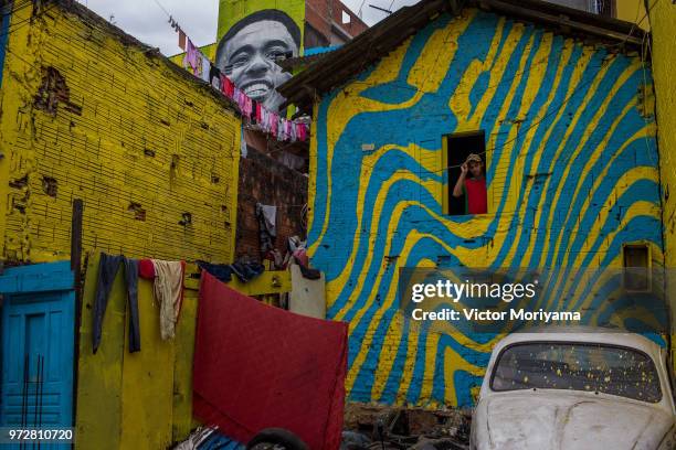 Children play soccer in front of the graffiti mural of the striker of the Brazilian soccer team Gabriel Jesus on June 12, 2018 in Sao Paulo, Brazil....