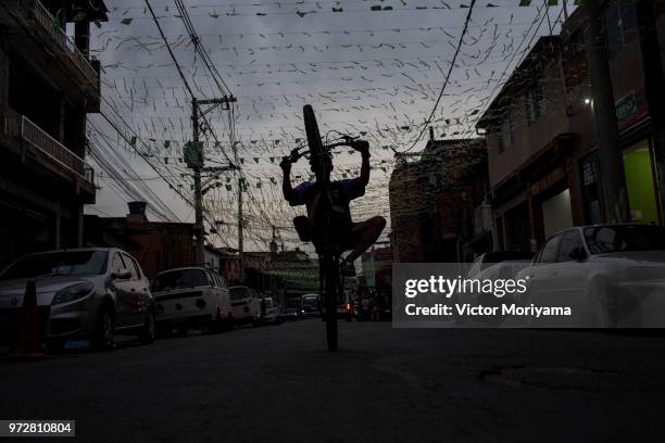 Boys pedal cycling in streets adorned with Brazilian flags in celebration of the 2018 World Cup in Russia on June 12, 2018 in Sao Paulo, Brazil. ....