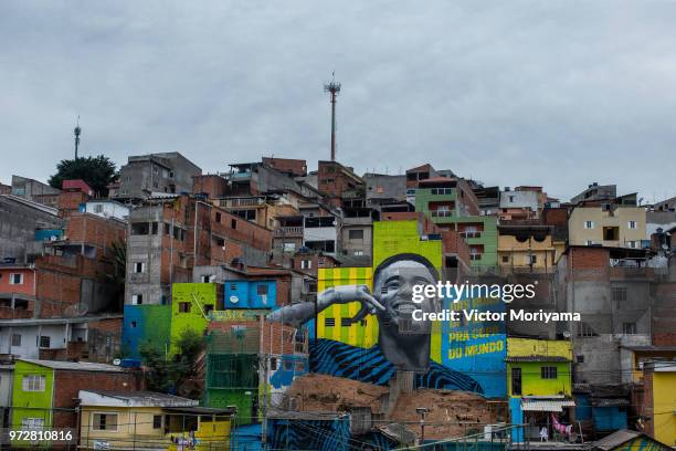 Children play soccer in front of the graffiti mural of the striker of the Brazilian soccer team Gabriel Jesus on June 12, 2018 in Sao Paulo, Brazil....