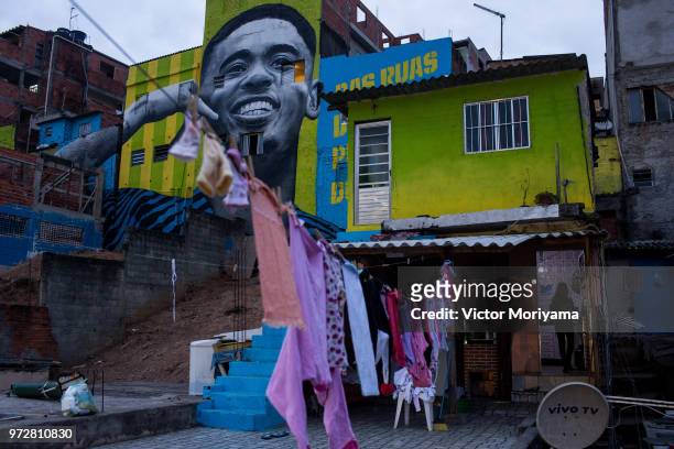 Children play soccer in front of the graffiti mural of the striker of the Brazilian soccer team Gabriel Jesus on June 12, 2018 in Sao Paulo, Brazil...