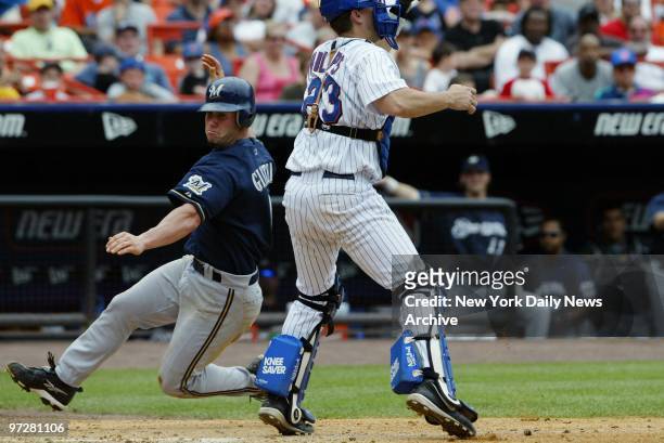 The Milwaukee Brewers' Keith Ginter scores from second on a single as New York Mets' catcher Jason Phillips waits for a high throw in the eighth at...