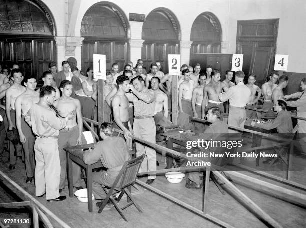 National Guardsmen of the 245th Coast Artillery take physical examinations in their Armory at Sumner and Jefferson Aves. Before being inducted into...