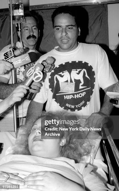 Lourdes Gonzales speaks to the press from her hospital bed at Bellevue. Behind her with hip hop tee shirt on is her boyfriend, Martin quinones.