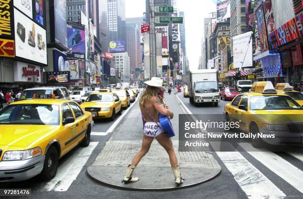 The Naked Cowboy, whose real name is Robert John Burck, strums his guitar and sings to passersby from a traffic median at 45th St. And Broadway....
