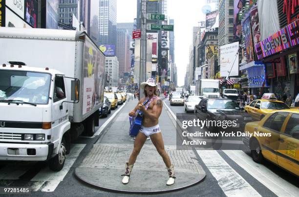 The Naked Cowboy, whose real name is Robert John Burck, strums his guitar and sings to passersby from a traffic median at 45th St. And Broadway....