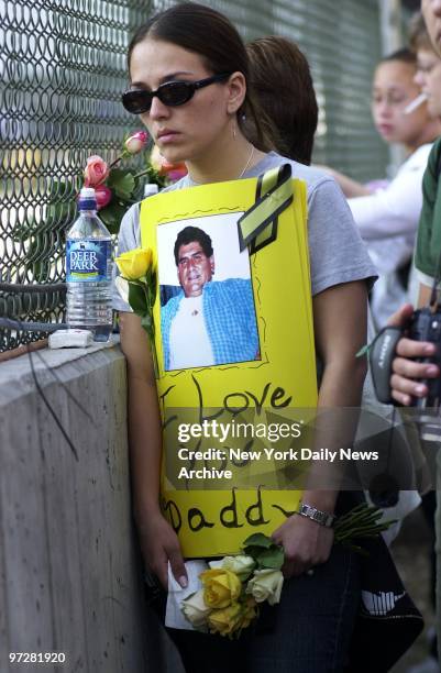 Forlorn woman holds flowers and a sign reading "I Love You Daddy" during ceremonies at Ground Zero commemorating the second anniversary of the...