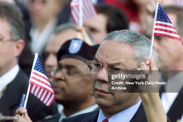 Secretary of State Colin Powell holds a flag at a memoral service at the Pentagon for those lost in the terrorist attack on the building a month ago...