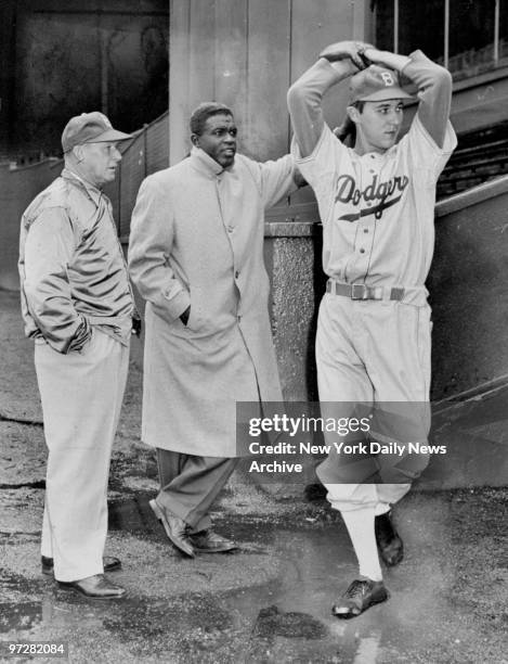 Brooklyn Dodgers' Billy Loes winds up as Chuck Dressen and Jackie Robinson during practice at the Polo Grounds in Brooklyn.