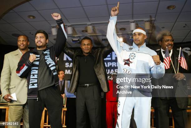 Former boxer Felix Trinidad holds up the hands of John Ruiz and Fres Oquendo as promoter Don King looks on at Madison Square Garden. King announced a...