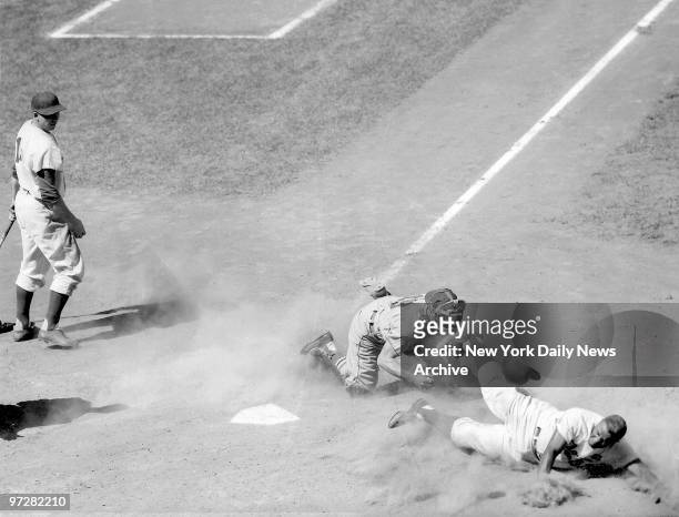 Brooklyn Dodgers' Jackie Robinson doesn't make out so well as he's tagged out by St. Louis Cardinals' Nelson Burbrink while trying to steal home in...