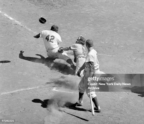 Brooklyn Dodgers' Jackie Robinson is tagged out trying to steal home by St. Louis Cardinals' catcher Nels Burbrink. Gil Hodges, who missed on a bunt...