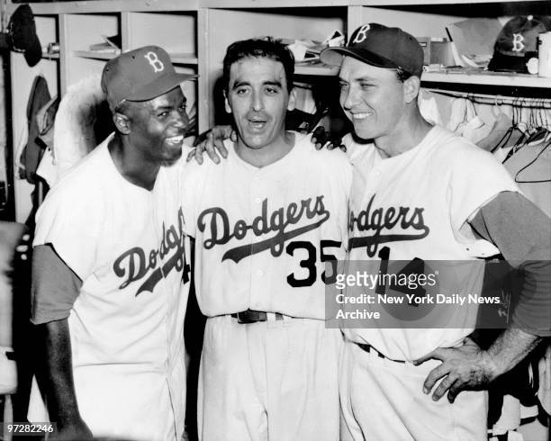 Brooklyn Dodgers' Jackie Robinson, Sal Maglie and Gil Hodges celebrate in the locker room after the Dodgers beat the New York Yankees in Game 1 of...