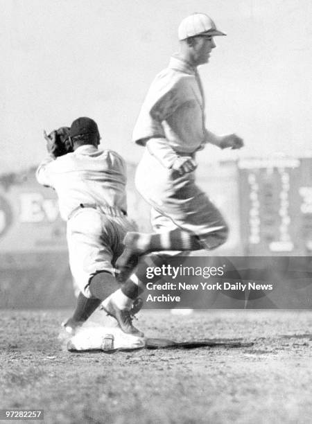Brooklyn Dodgers' Jigger Statz beats out a bunt at third as Lou Gehrig covers the bag for the New York Yankees during game at Ebbets Field.