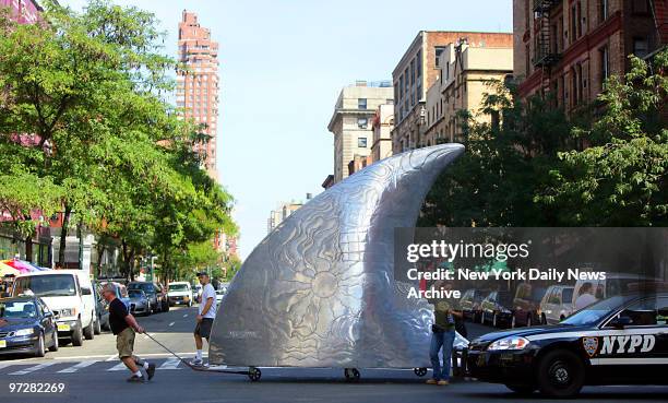 James Johnson pulls his giant polished aluminum shark fin sculpture, entitled "Freedom of Movement," across W. 72nd St. To the 68th St. Pier. It was...