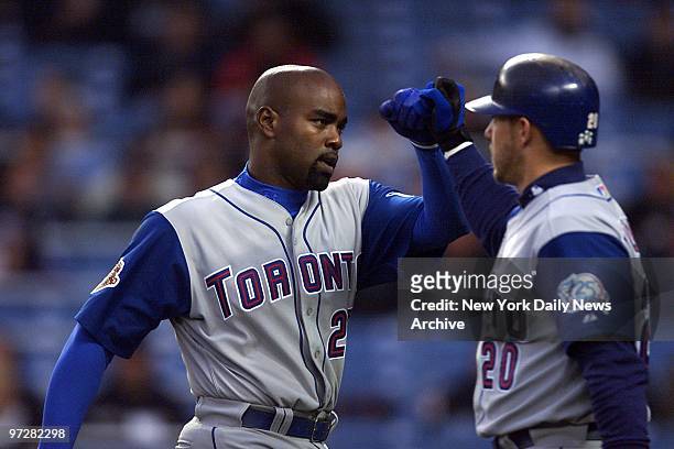 Toronto Blue Jays' Carlos Delgado is congratulated by Brad Fullmer after slugging a first-inning two-run homer against the New York Yankees. It was...