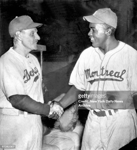 Brooklyn Dodgers' manager Leo Durocher shakes hands with Jackie Robinson in Havana before the Dodgers played Montreal.