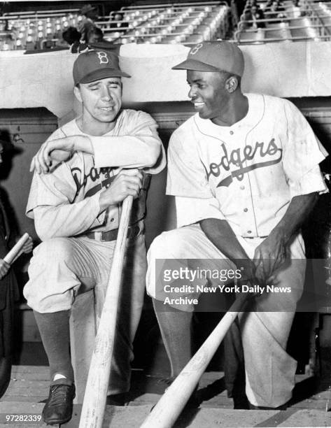 Brooklyn Dodgers' Pee Wee Reese and Jackie Robinson chatting in dugout at Yankee Stadium.
