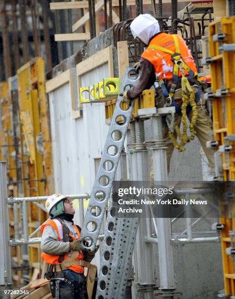 Croton Water Filtration Plant. Workers at Water Filtration Plant under construction. Moving braces from one worker to another.