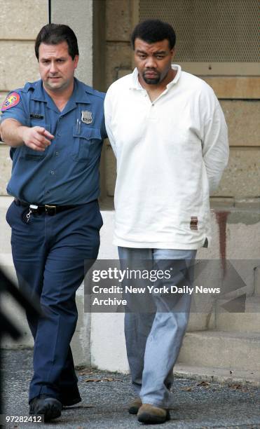 Nassau County police officer escorts Baldwin High School choir teacher Anthony Marshall, of Massapequa, L.I., from Nassau County Police Department...