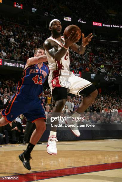 LeBron James of the Cleveland Cavaliers glides in for the layup trailed by David Lee of the New York Knicks on March 1, 2010 at The Quicken Loans...