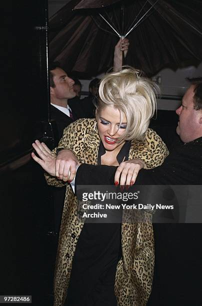 Security guard holds door for Anna Nicole Smith on a snowy night as she enters Studio 54 to model in plus-size retailer Lane Bryant's spring/summer...