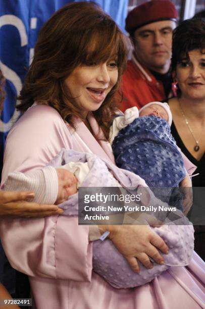 Twins Francesca and Gian snooze through their first news conference in the arms of their smiling mother, Aleta St. James, on the day after the babies...