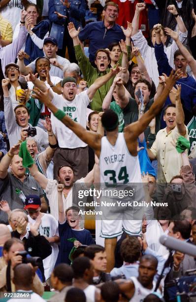 Crowd cheers wildly as Boston Celtics' Paul Pierce leaps up on scorer's table at end of Game 3 of the Eastern Conference finals against the New...