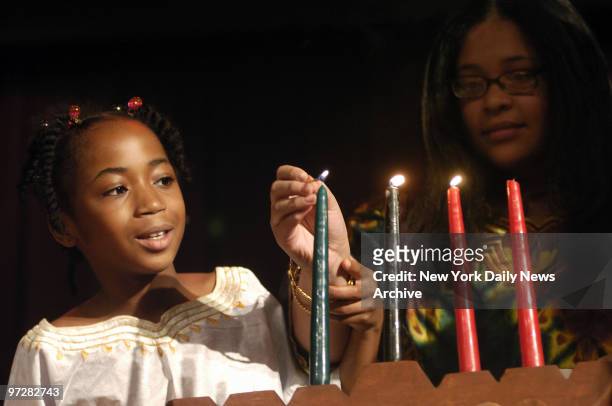 Brooklyn students light a candle celebrating Ujamaa , one of the Seven Principles of Kwanzaa, during a celebration at the American Museum of Natural...