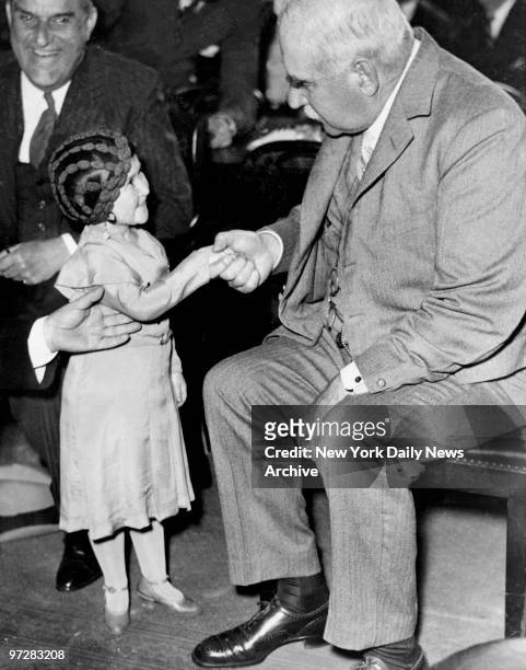 Lya Graf, 31-year-old circus midget smiles as J.P. Morgan gravely shakes hands with her in the banking committee room where the Morgan inquiry is...