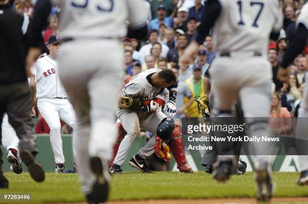 New York Yankees and Boston Red Sox players race out of the dugout as Yanks' Alex Rodriguez is tackled by Red Sox's catcher Jason Varitek in the...