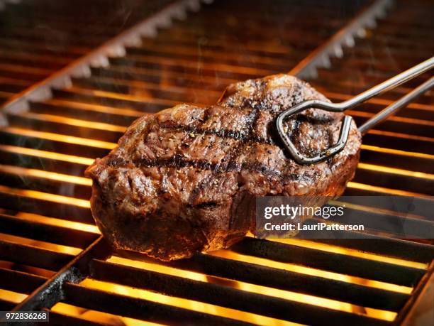 bifes de lombo de vaca para churrasco - pinça utensílio de servir - fotografias e filmes do acervo