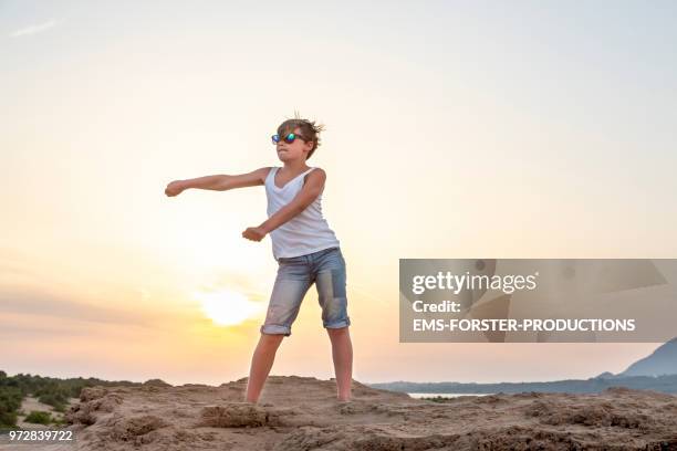 boy dances the fortnite floss move, aka swish shish dance, a on-trend dance inspired by the survival video game fortnite. - dental floss stock pictures, royalty-free photos & images