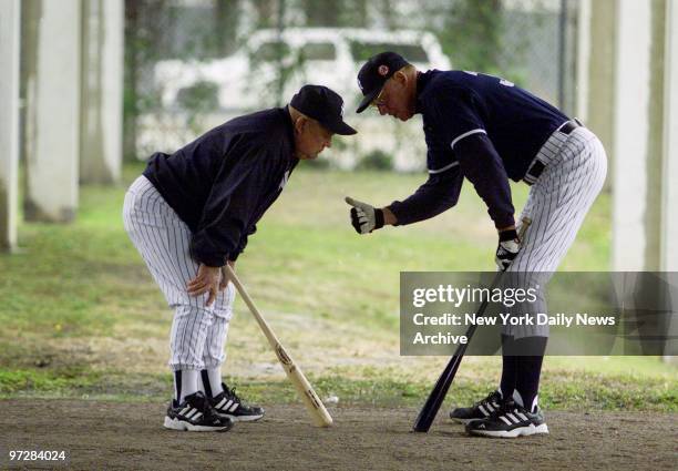 New York Yankees' bench coach Don Zimmer and player development coach Frank Howard confer as they take shelter under Legends Field stadium during a...