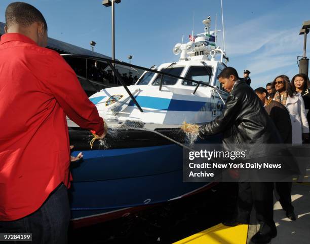 Christian Andrews and Stephan Nemorin break bottles yesterday against newest additions to the NYPD's harbor division, a 40-foot boat dedicated to...