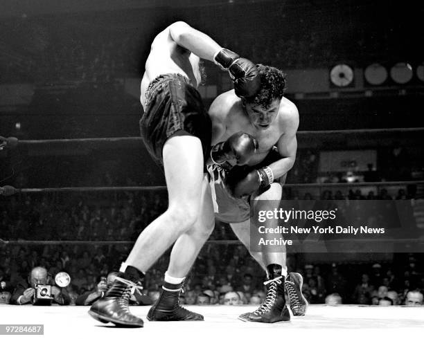 Chuck Taylor ducks and covers up as Tony Janiro scores a right to his head in the third round of main event at Madison Square Garden. Welterweight...