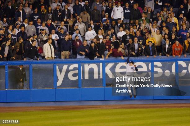 New York Yankees' Bubba Crosby leaps to catch a ball over the left field fence to rob Boston Red Sox's Mike Lowell of a homer in the third inning at...