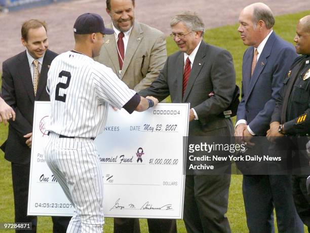 New York Yankees' captain Derek Jeter presents Virginia Tech president Charles Steger with a check for $1 million to go to the Hokie Spirit Memorial...