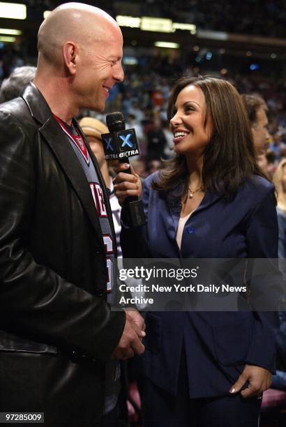 Bruce Willis is interviewed by Joumana Kidd, wife of New Jersey Nets' Jason Kidd, during Game 3 of the NBA Finals between the Nets and San Antonio...
