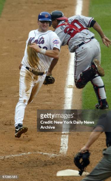 The New York Mets' Jason Phillips scores from third on a sacrifice fly as Atlanta Braves' catcher Henry Blanco misses the throw in the fourth at Shea...