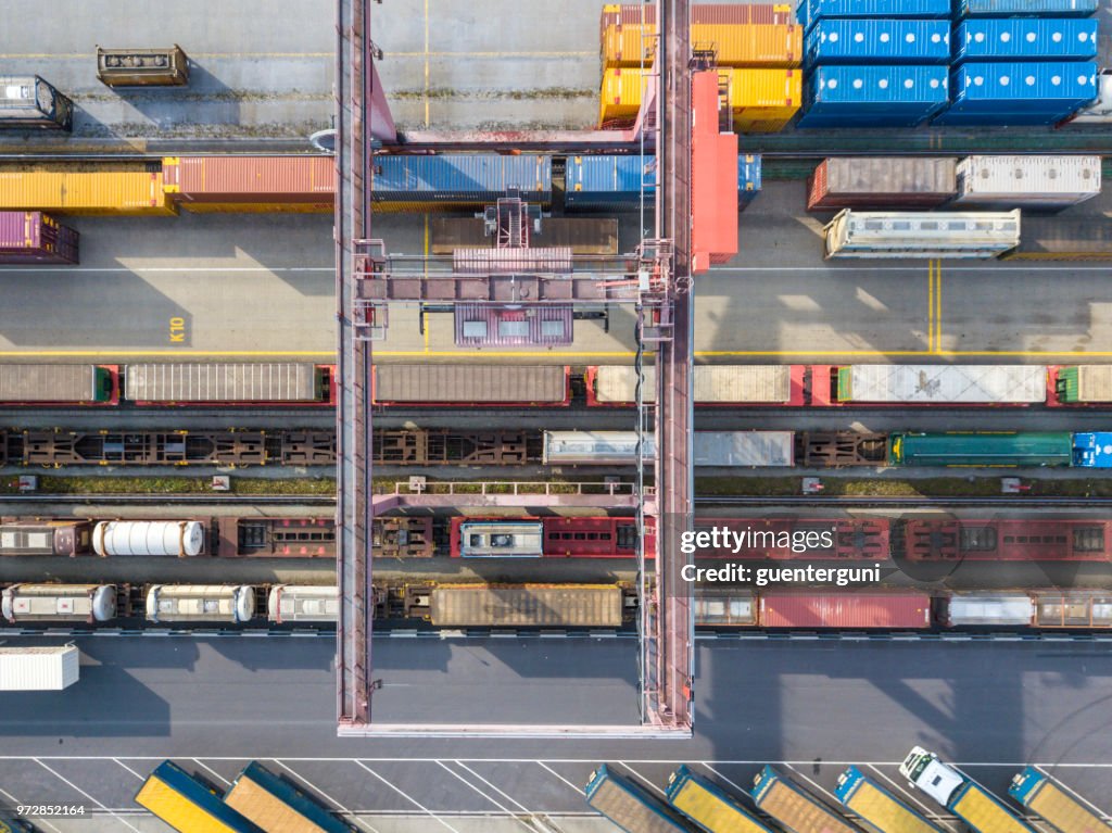 Cargo trains, trucks and a huge crane at freight terminal, Austria