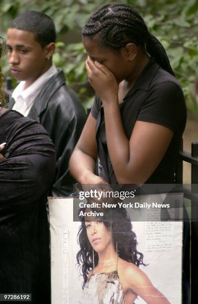 Shatika Wallace of Longbranch, N.J., holds a hand-lettered tribute to R&B star Aaliyah as she weeps outside the Frank E. Campbell Funeral Chapel on...