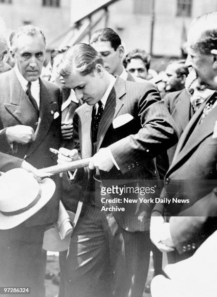 Nelson Rockefeller autographing spade used to break ground at Rockefeller Center.